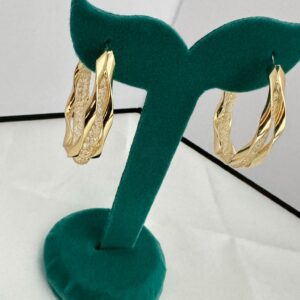 Intertwined twisted gold hoop earrings with one polished strand and one textured strand
