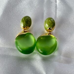Green statement dangle earrings with swirled olive enamel tops and translucent frosted green round stones with gold trim on a white satin background.