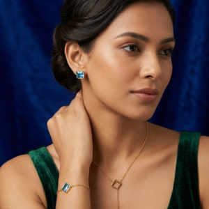 gold lariat necklace, square blue crystal stud earrings, and matching bracelet.
